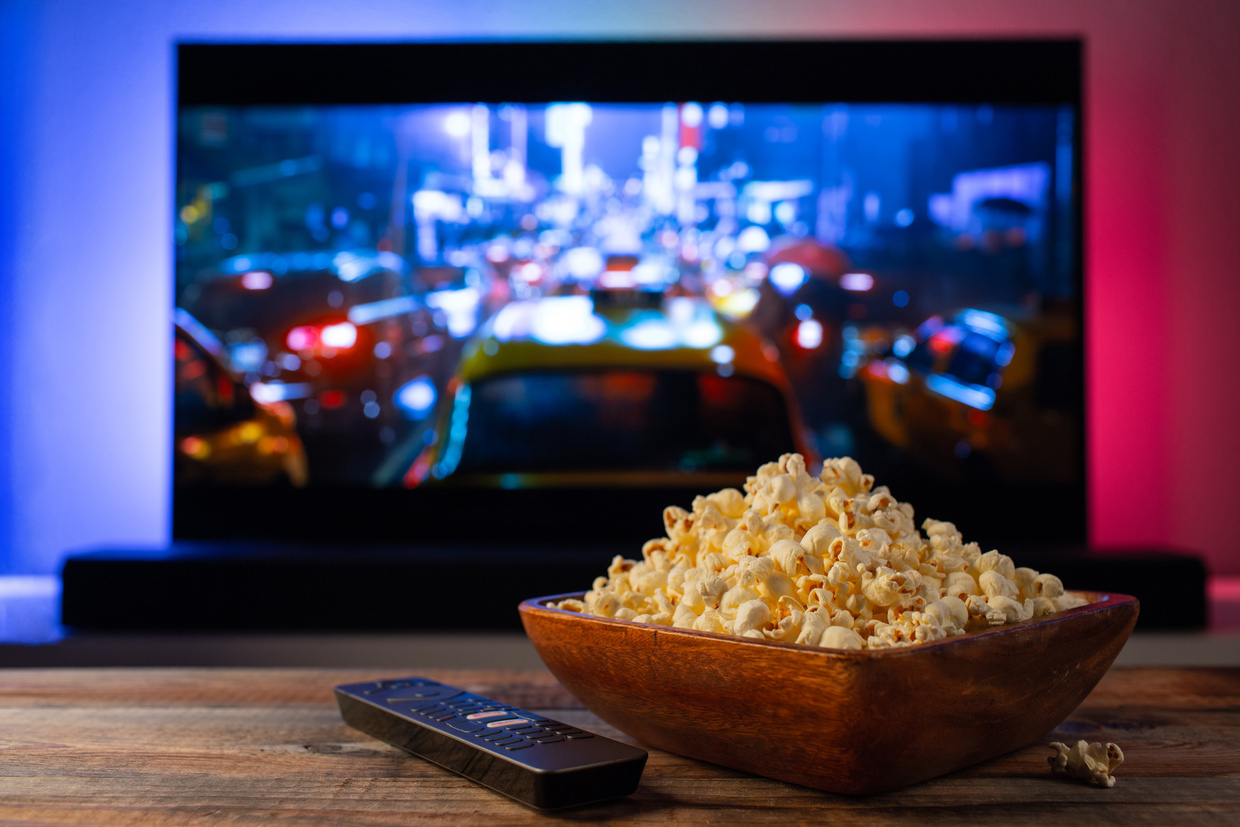 Wooden Bowl Filled with Popcorn beside the TV Remote 