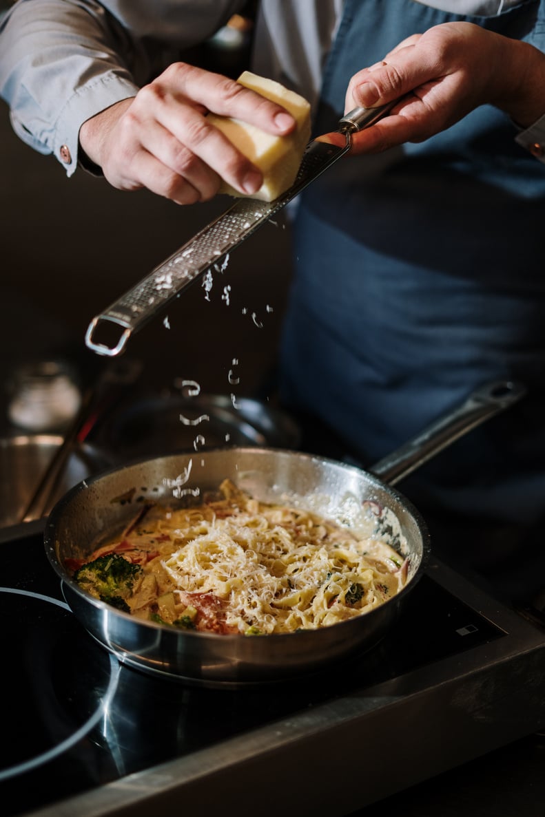 Person Holding Stainless Steel Cooking Pot With Pasta